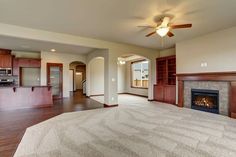 an empty living room with wood flooring and fireplace