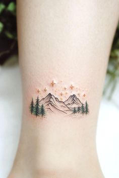 a woman's foot with mountains and stars on it