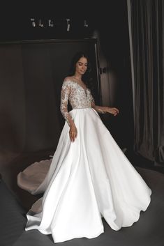 a woman in a white wedding dress posing for the camera