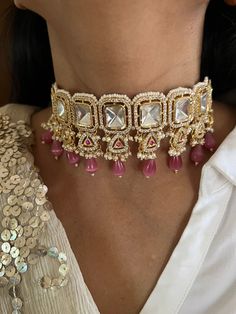 Discover the epitome of elegance with our premium choker set. Crafted with precision and designed to turn heads, this set is a true masterpiece. Product Details: Material: Each piece is meticulously handcrafted from high-quality brass, copper, gold plating, Kundan work CZ Stones, Peach Beads,  Choker Dimensions: Weight: 70 grams Closure Type: Premium Dori Adjustable Size: Yes Earring Dimensions (Per Pair): Weight: 16 grams Closure Type: Push Back  Exquisite Design: This set boasts a design that' Formal Bridal Choker With Tilla, Elegant Kundan Choker Necklace With Tilla, Elegant Kundan Choker Necklace For Ceremonial Occasion, Elegant Kundan Bridal Choker Necklace, Elegant Kundan Choker For Formal Occasions, Elegant Hand Set Choker For Ceremonial Use, Elegant Hand Set Choker For Festive Occasions, Elegant Hand Set Choker For Ceremonial Occasions, Elegant Hand Set Festive Choker