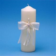 a white candle with a ribbon around it