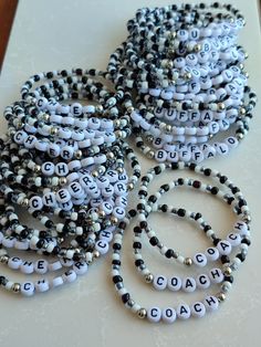 several bracelets with words written on them sitting on a table next to each other