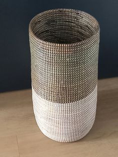 a white and black basket sitting on top of a wooden table