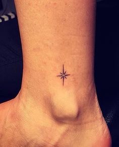 a small tattoo on the ankle of a woman's foot, with a star