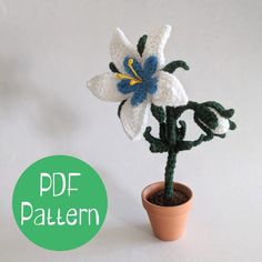 a crocheted flower in a pot on a white surface