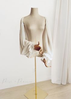 a mannequin wearing a white blouse with ruffles on it's sleeves