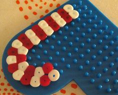 a cake shaped like a cat in the hat on top of a blue mat with buttons