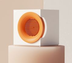 an orange speaker sitting on top of a white box in front of a beige wall