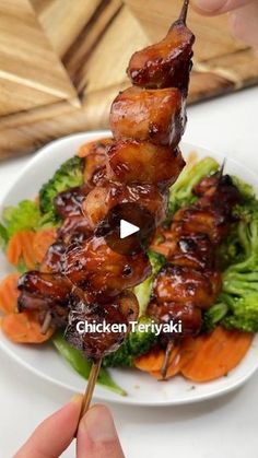 chicken and broccoli skewers on a white plate with chopsticks