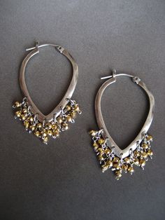 This item is made to order please allow 5 to 8 business days for your order to ship. This pair of earrings is the perfect alternative to a classic round hoop earring. The two tone combination of gold and silver, makes this pair very versatile and can easily be worn from day into evening. The hoops are solid sterling silver that have been lightly oxidized. Tiny faceted golden pyrite beads are individually hand wire wrapped, and dangle as a cluster from the hoop. They measure 1 3/4 inches in lengt Silver Sterling Hoop Earrings With Dangling Beads, Silver Teardrop Jewelry With Dangling Beads, Silver Teardrop Brass Earrings, Nickel-free Dangle Hoop Earrings For Festive Occasions, Silver Drop Beaded Jewelry, Festive Nickel-free Dangle Hoop Earrings, Elegant Beaded Sterling Silver Hoop Earrings, Silver Metal Beaded Hoop Earrings, Gold Beaded Sterling Silver Earrings