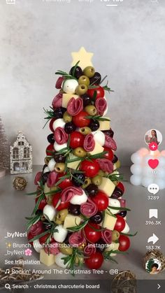 a christmas tree made out of cheese and olives is shown on the phone screen