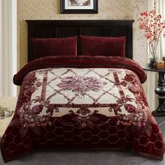 a bed with a red and white comforter on top of it