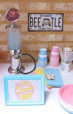 a table topped with plates and cups next to a sign that says fuel by here