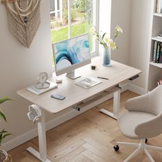 a desk with a computer on it in front of a window and bookshelf