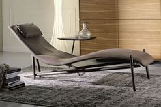 a living room scene with focus on the chaise lounger and glass coffee table