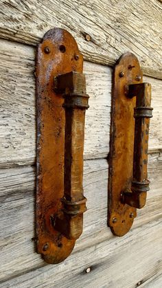 two rusted metal hooks on the side of a wooden wall