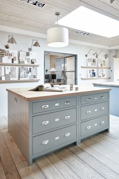 a large kitchen with lots of drawers and shelves on the wall next to an island