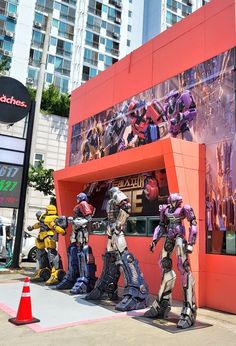 a group of mannequins dressed as robots in front of a movie store