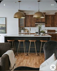 an open concept kitchen and living room with bar stools in front of the island