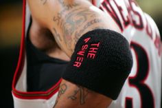 a close up of a basketball player with tattoos on his arm