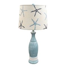 a table lamp with a starfish print shade on the base and a white drum light behind it