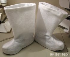 two pairs of white slippers sitting on top of a counter next to a sewing machine