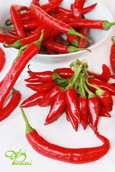 some red peppers are in bowls on a table