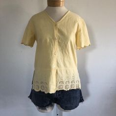 ★ sale! take 30% off 2 items, 40% off 3 items, and 50% off 4 items or more! discount automatically applies at checkout. ★This is a vintage pale yellow cotton top. Blouse is short sleeved with scalloped hem at the sleeves and the waist, buttons down the front, and cut out and sequin details on the bottom.era: 1990slabel size: S [please check measurements]fits like: small/mediummeasurements:bust: 38"hem: 38"length: 24"material: 100% cottonbrand/maker: Jane Ashleycondition: excellent vintage condit Vintage Cotton V-neck Top, Cottagecore Short Sleeve Top For Spring, Vintage Cotton V-neck Blouse, Classic Yellow Short Sleeve Tops, Vintage V-neck Top For Daywear, Cottagecore Cotton Short Sleeve Tops, Classic Yellow Summer Blouse, Vintage V-neck Cotton Blouse, Vintage Cotton Tops For Spring