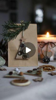 a christmas tree ornament sitting on top of a table next to a candle