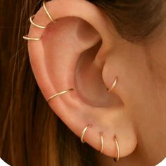 a close up of a person's ear with three different types of piercings