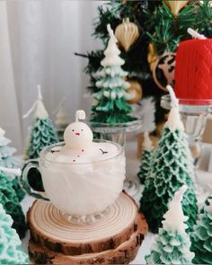 there is a tea cup with a small toy in it on top of a tree stump