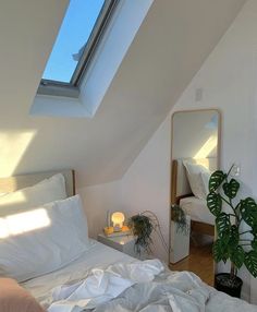 a bed with white sheets and pillows under a skylight