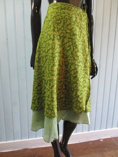 Vintage silk wrap skirt in lovely spring green with yellow flowers. Has a contrasting underskirt.  Dimensions: Waist flat: 46 Inches. Length: 32 Inches. Made in India Green Bohemian Long Wrap Skirt, Bohemian Green Long Wrap Skirt, Bohemian Green Wrap Skirt For Festival, Green Tiered Sundress, Green Tiered Skirt Sundress, Green Summer Dress With Relaxed Skirt, Green Sundress With Tiered Skirt, Green Bohemian Long Dress, Bohemian Silk Skirt For Spring