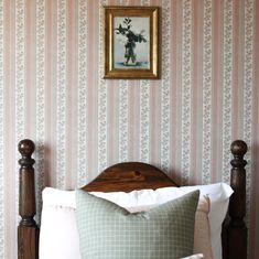 a bed with a wooden headboard and two framed pictures on the wall above it