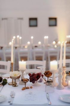 the table is set with candles, plates and desserts for an elegant wedding reception