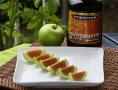 slices of melon on a white plate next to a bottle of buttershots