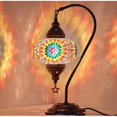 a colorful lamp is lit up on a table