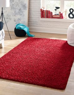 a bright red rug is in the middle of a room