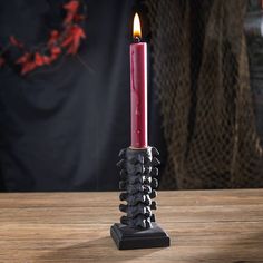 a red candle sitting on top of a wooden table