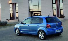 a blue car parked in front of a building with an arrow pointing to the camera