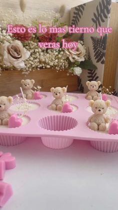 there are many small teddy bears in the cupcakes on the table with pink icing