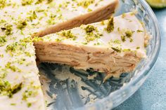 a cake with white frosting and green sprinkles is cut into slices