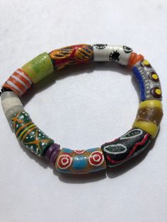 "This colorful bracelet is handmade from recycled glass, formed into beads known as Krobo beads, hand painted, and fired in a kiln in Ghana, West Africa.  The bracelet is 7 1/2\" and is strung on 2mm white elastic cord. It features hand-painted African designed glass beads. Other sizes may be ordered as well as earrings and other jewelry. Just contact us.  All proceeds from the sale of this jewelry go to our non-profit organization Mawuvio's Outreach Programme, which is providing free education and care for orphaned and disadvantaged children in Ghana. The money is used to support a 6 classroom and 2 dormitory school that provides over 200 children with the tool they need to succeed - Education. Students & staff at Mawuvio's Outreach Programme string the beads themselves to create handmade Handmade Multicolor Recycled Glass Beads, Multicolor Glass Beaded Festival Bracelets, Adjustable Recycled Glass Beads With Large Beads, Handmade Adjustable Recycled Glass Beads, Artistic Adjustable Beaded Bracelets, Colorful Recycled Glass Beaded Bracelets As Gift, Colorful Recycled Glass Beaded Bracelets For Gift, Adjustable Multicolor Beaded Bracelets In Wearable Art Style, Wearable Art Adjustable Multicolor Beaded Bracelets