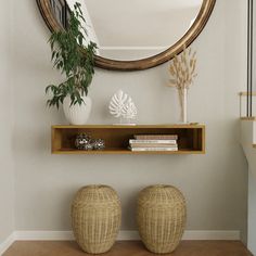 two wicker stools sit in front of a round mirror on the wall next to a shelf with books