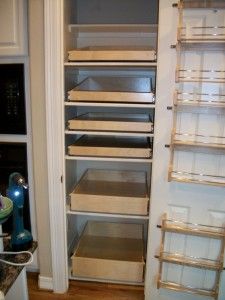 an empty pantry with wooden shelves and drawers