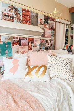 a bed with lots of pillows and pictures on the wall