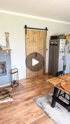 a kitchen with a table and refrigerator in it