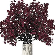 a white vase filled with red flowers on top of a table