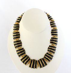 "Stunning black enamel and gold tone Egyptian Revival necklace and clip on earrings set. The necklace features black enamel and gold tone links. These pieces are unsigned, but clearly a high end brand. The necklace is very heavy which is a reflection of its high quality. Showstopping, runway pieces. Excellent vintage condition. Slight signs of wear where each link connects on the necklace. Otherwise, flawless. Necklace measures 17.75\" long from clasp to clasp. Approximately 1.1\" wide. Earrings Black Enamel Jewelry For Evening, Unique Gold Jewelry With Black Enamel, Gold Jewelry With Black Enamel For Party, Yellow Gold Jewelry With Black Enamel For Evening, Gold Jewelry With Black Enamel For Formal Occasions, Gold Enamel Necklace For Party, Gold Enamel Party Necklace, Black Enamel Party Jewelry, Gold Metal Jewelry With Black Enamel