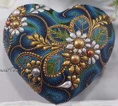 a blue and gold heart shaped box sitting on top of a table